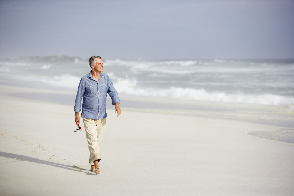 Happy older man on beach.