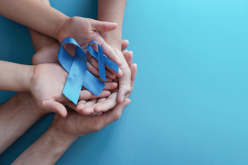 blue ribbons in hands - a prostate cancer awareness concept