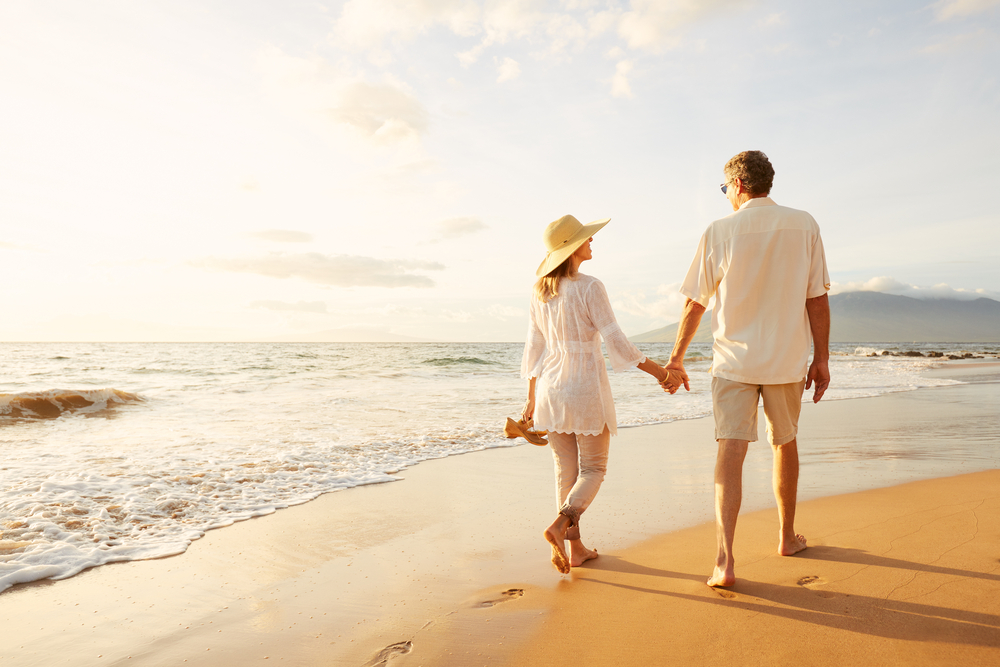 Happy couple walking on a beach.