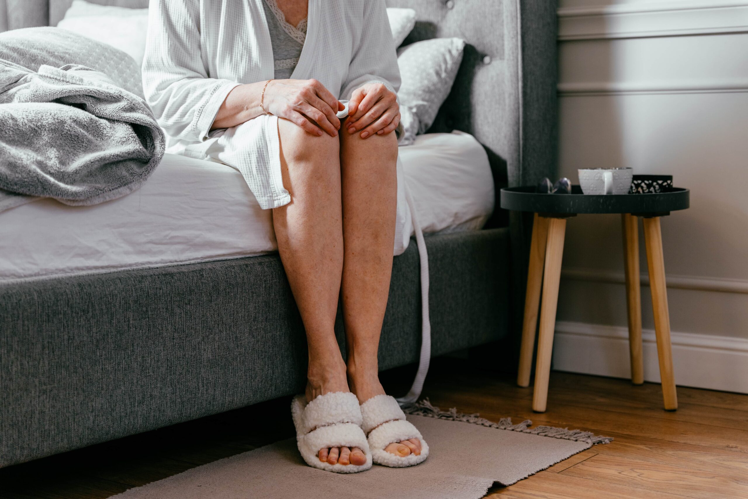 Woman sitting on the side of the bed.